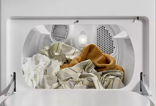Large capacity Whirlpool dryer drum with a full load of laundry inside.